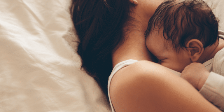 Maman qui dort avec son bébé dans les bras